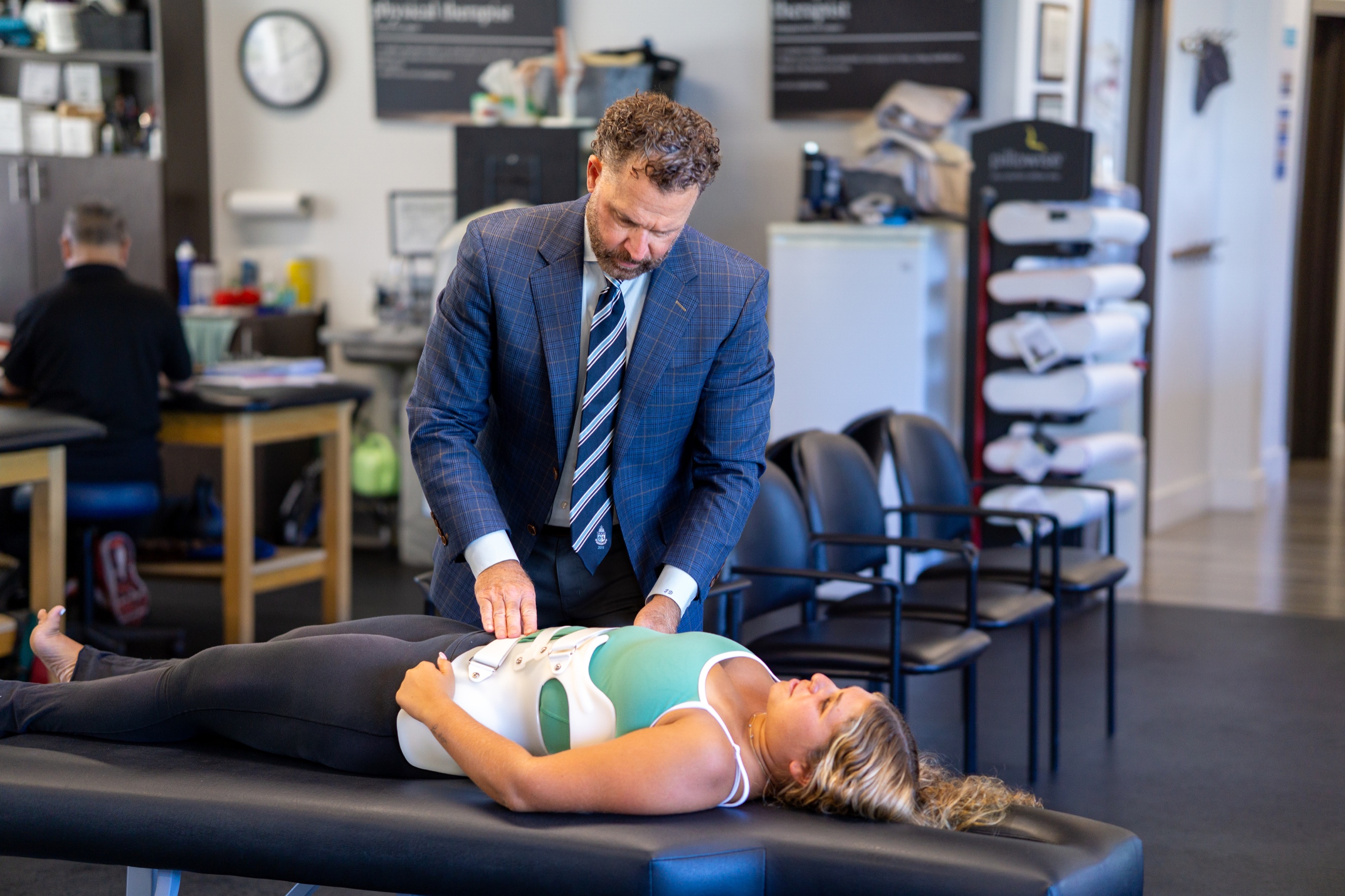 Scoliosis specialist providing hands-on treatment to a patient wearing a custom brace