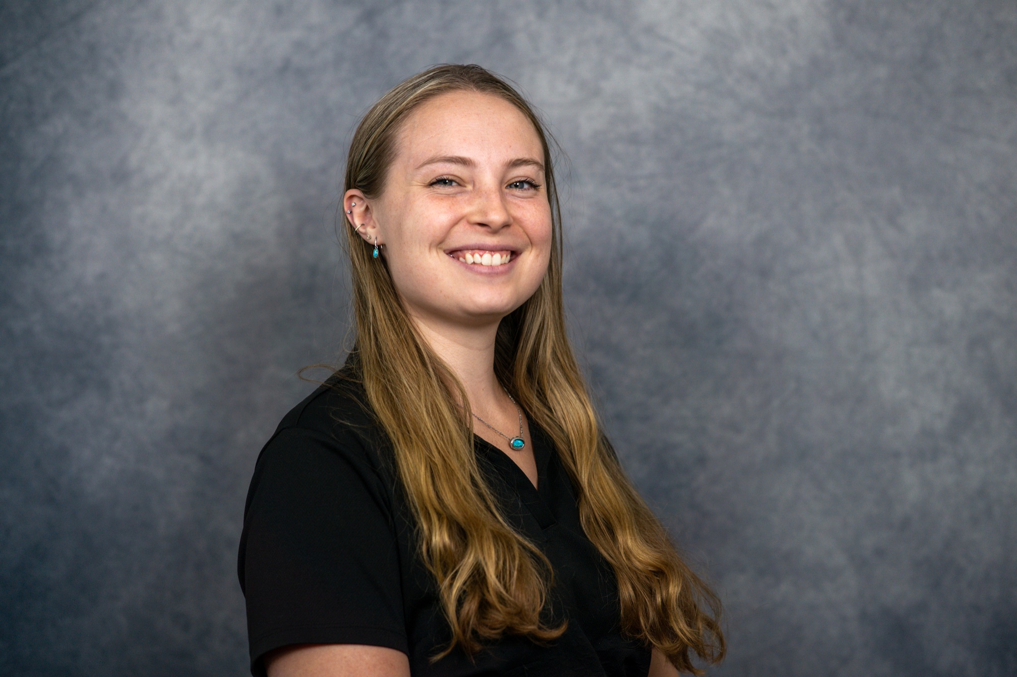 Professional on-site headshot of a smiling practice team member