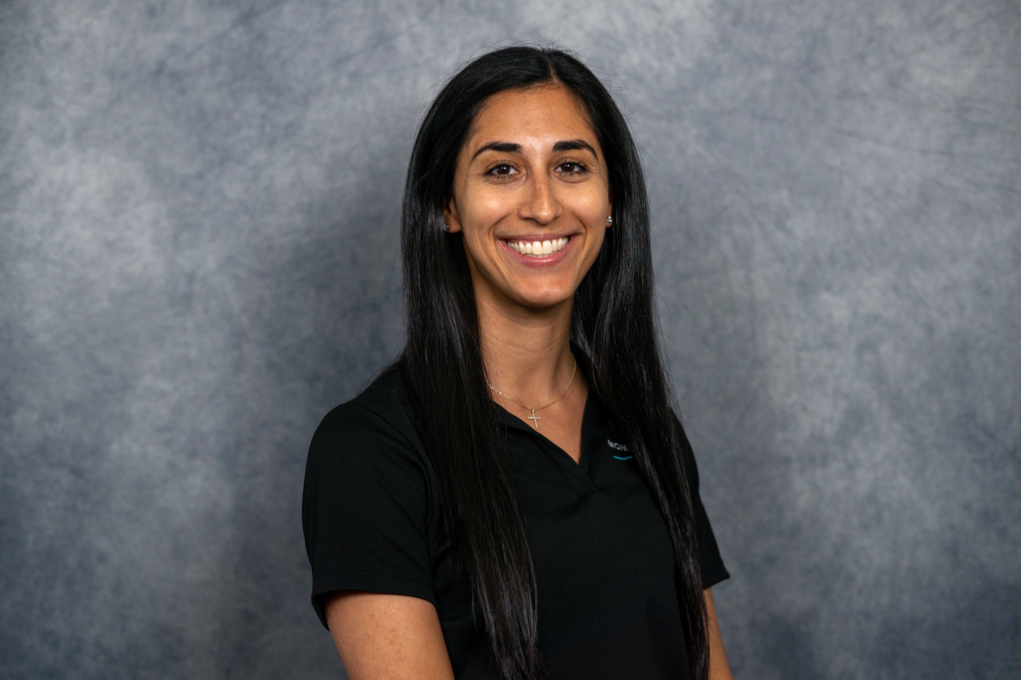 Professional on-site headshot of a practice team member in a black polo